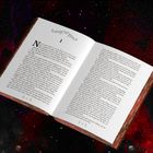 Ein aufgeschlagenes Buch zeigt Kapitel 1 in einem roten, sternenklaren Hintergrund. Verschnörkeltes Design am Anfang.