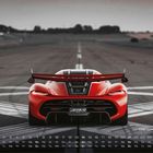 Koenigsegg Jesko 2. Ein rotes Auto auf einer Rennstrecke, von hinten gesehen. Unten ist ein Monat mit Datum aufgelistet.