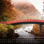 Shinkyō (Fußgängerbrücke) über Fluss Daiya, Stadt Nikkō. Kalender unten. Rot-orange Brücke in herbstlicher Landschaft.
