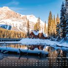 Kalender mit Text: "Emerald Lake Lodge, Yoho Nationalpark". Schneebedeckte Berghütte, Bäume, reflektierender See und Berge.