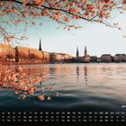 Text: "Binnenalster", "2", Kalenderdaten 1 bis 28. Frühlingshafte Szenerie mit blühenden Bäumen und einer Stadtansicht am Wasser.