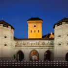 Kalender für Februar, mit "isartor" und der Zahl "2". Historisches Tor bei Nacht, Uhr im Turm, bemalte Fassade.
