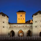 Isartor, Kalender mit Daten und Wochentagen im Vordergrund. Historisches Tor mit zwei Türmen und Uhr bei Abenddämmerung.