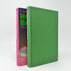Zwei Bücher, eines mit grünem Einband, das andere zeigt einen Buchrücken mit rosa, grüner und weißer Schrift.