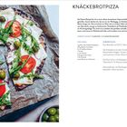 Knäckebrotpizza: Rezept und Anleitung mit Tomaten, Zwiebeln, Oliven und Rucola auf einem gebackenen, belegten Knäckebrot.