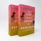 Buchtitel: "The Iced Caramel Coffee Agreement" von Kyra Groh. Illustration: Frau auf Fahrrad mit Blumen.