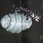 "METAMORPHOSIS, 2015" bei Nacht, eine weiße, beleuchtete Skulptur hängt zwischen Bäumen in der Dämmerung.