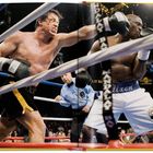 Ring, "Dixon", "ROCKY" auf Hosen. Zwei Boxer im Schlagabtausch, ein Schiedsrichter beobachtet. Dynamische Szene im Boxring.