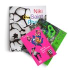 Drei Bücher mit Titeln: "Niki de Saint Phalle", "Die Grütte", "Niki de Saint Phalle A-Z". Farbenfrohe Cover mit Kunstwerken.