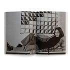 Eine Person liegt auf einer Couch. Im Hintergrund ist ein geometrisches Muster an der Wand.