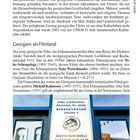 Texte: "Shota Rustaveli Theatre and Film University".  
Eine Tafel an einem Gebäude mit Spiegelungen von Fenstern.