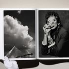 Links Wolken über Pyramide, rechts rauchender Mann mit Ringen. Ein Handschuh hält das Buch.