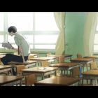 Ein junger Mann sitzt auf einem Schreibtisch in einem leeren Klassenzimmer und liest ein Buch.