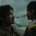 Ein Mann und eine Frau stehen sich festhaltend gegenüber. Der Himmel ist bewölkt, und sie scheinen besorgt.