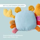"MIT ALLEN SINNEN ERLEBEN. Unterschiedliche Strukturen laden zum Fühlen ein." Bunte, weiche Stoffdetails ohne klare Form.