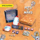 Text: "SPIELAUFBAU", "PETS ON MARS". 
Illustration mit verspieltem Weltraum-Thema, Raketen und Figuren.