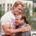 Auf einem T-Shirt steht "Born to be Bad". Zwei Männer umarmen sich herzlich im Freien.
