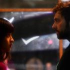 Zwei Personen stehen sich gegenüber, schauen sich intensiv an, umgeben von weichem, diffusem Licht.