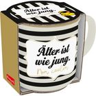 „Älter ist wie jung. Nur cooler.“ steht auf einer gestreiften Tasse in einer Verpackung, daneben ein gezeichneter Kopf.