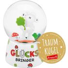 Text: "GLÜCKSBRINGER", "TRAUMKUGEL". Eine Schneekugel mit Schaf hält ein Kleeblatt. Sockel mit Pilzen dekoriert.