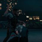 Zwei Männer kämpfen nachts auf einem Dach, umgeben von Graffiti und Lichtern einer Stadt im Hintergrund.