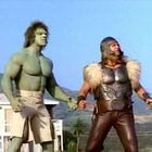 Zwei muskulöse Männer: einer grün und kräftig, der andere trägt einen Wikingerhelm und Fell an den Schultern.