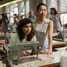 Zu sehen ist eine alte Nähmaschine mit „SINGER“-Schriftzug. Zwei Frauen stehen konzentriert an der Maschine.