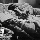 Text: "FBI Agent Eddie wieder Colt-Richtig." Zwei Personen schlafen auf einem floral gemusterten Sofa.
