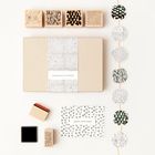 "Congratulations" auf einer Geschenkbox, "Happy Birthday" auf einer Karte. Bastelutensilien mit Mustern sind zu sehen.