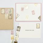 „Sending you a hug“ auf Karte, daneben Briefmarken mit Pflanzenmotiven, ein Karton und eine Marke „With love.“