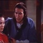 Personen in traditioneller asiatischer Kleidung, scheinbar in einem Gespräch. Exotische Atmosphäre durch Kleidung und Umgebung.