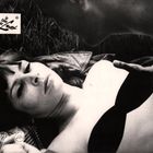 Text: "Im Reich der Lust". Eine Frau liegt mit geschlossenen Augen auf dem Rücken im Gras. 