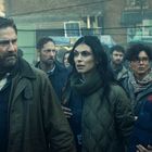 Mehrere Menschen stehen zusammen und schauen besorgt in dieselbe Richtung. Die Szene wirkt angespannt und dramatisch.