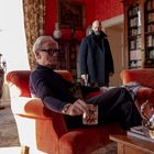 Eine gediegene Bibliothek, zwei Männer: einer sitzt mit Whisky, der andere steht mit ernster Miene und einer Waffe.