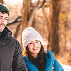 Es gibt keinen Text zu erwähnen. Ein Mann und eine Frau in Winterkleidung lächelnd im Freien.
