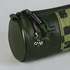 Der Text "s-maepp" steht auf einem Etikett an einem grünen zylindrischen Lederbeutel mit einem Karoflaggen-Anhänger.