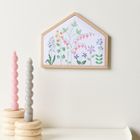 Kein Text zu erkennen. Stickerei mit bunten Blumen in einem sechseckigen Holzrahmen. Zwei gedrehte Kerzen in Holzhaltern.