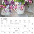 Kalender für Mai 2027; Wochentage in Deutsch und anderen Sprachen. Zwei Blumengestecke in Porzellantassen.