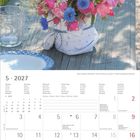 5 · 2027, Rosen, Kornblumen, Wiesenkerbel. Ein bunter Blumenstrauß steht auf einem Holztisch im Freien.