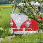 Mai 2027. Wochenkalender. Roter VW-Bus in grüner Landschaft, im Vordergrund blühender Baum.