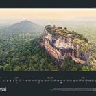 Mai, Kalendertage 1 bis 31. GEO. Eine große Felsformation mit grüner Landschaft oben, umgeben von üppigem Wald.