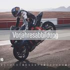 „Vorjahresabbildung“, „APR 26“, ein Motorradfahrer macht einen Wheelie auf einer Rennstrecke.