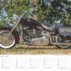 Kalenderseite Juni, Motorrad auf Schotter, grüne Bäume im Hintergrund. Montag bis Sonntag in sechs Sprachen.