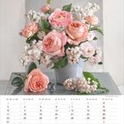 Kalender Mai mit Rosen und Flieder in einer Vase. Schönheit und Zartheit bestimmen das florale Arrangement.