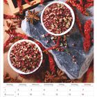 März 2027 Kalender. Gewürze auf Stein: rote Beeren in Schalen, rote Chilischoten, Sternanis.