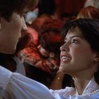 Ein Mann und eine Frau tanzen eng beieinander und schauen sich lächelnd an in einer Menschenmenge.