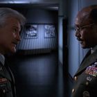 Zwei Männer in Militäruniformen, die sich in einem Flur unterhalten. Patches und Abzeichen schmücken ihre Uniformen.