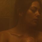 Ich kann keine Texte oder Personen in diesem Bild erkennen. Es zeigt eine Frau in einem dampfenden, dunklen Raum.