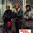 Text: "Blutiger Freitag. Ein Gloria-Farbfilm." Drei Männer mit Waffen vor einem Rollgitter, zwei tragen Jacken mit rotem Detail.