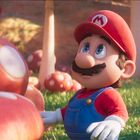 Der Buchstabe M auf der Mütze. Ein Mann in rotem Outfit und blauem Overall, umgeben von großen, gepunkteten Pilzen.